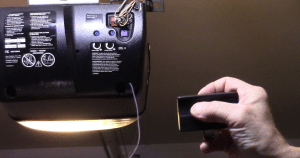 Man programs garage door with remote click.