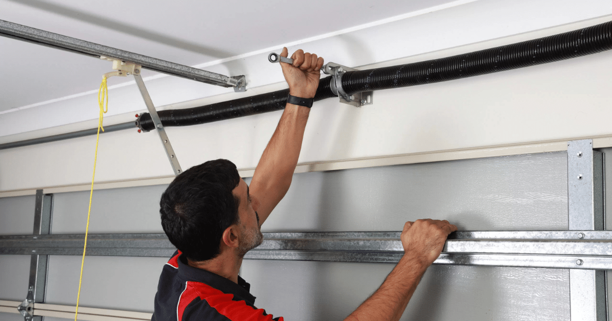 man fixing garage door torsion spring