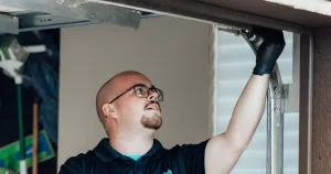 Technician inspecting garage door track.